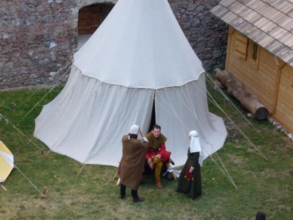 Drei Teilnehmer vor einem Zelt